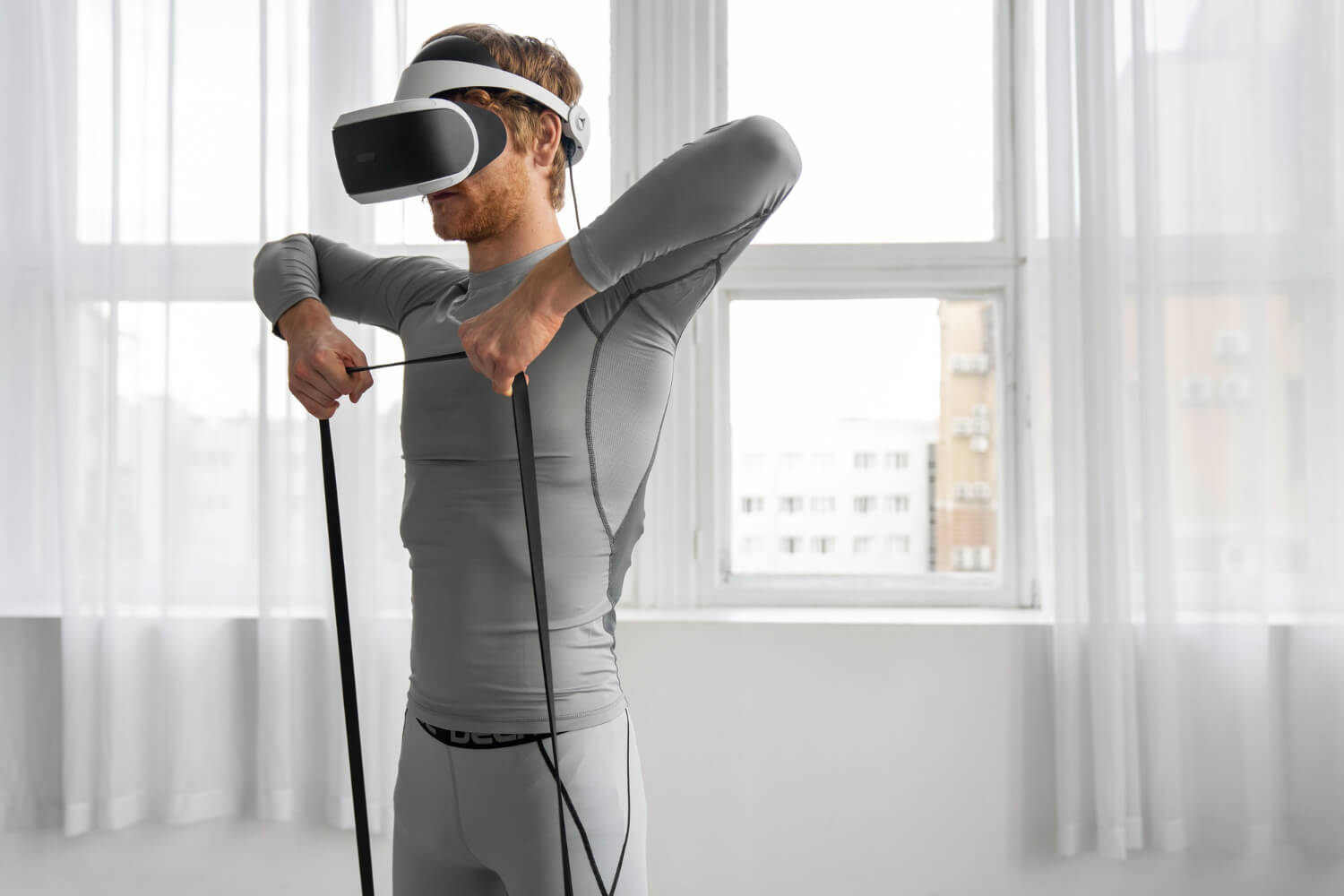 Slimme technologie: man staat rechtop, met een VR-bril, op en trekt een band recht omhoog.