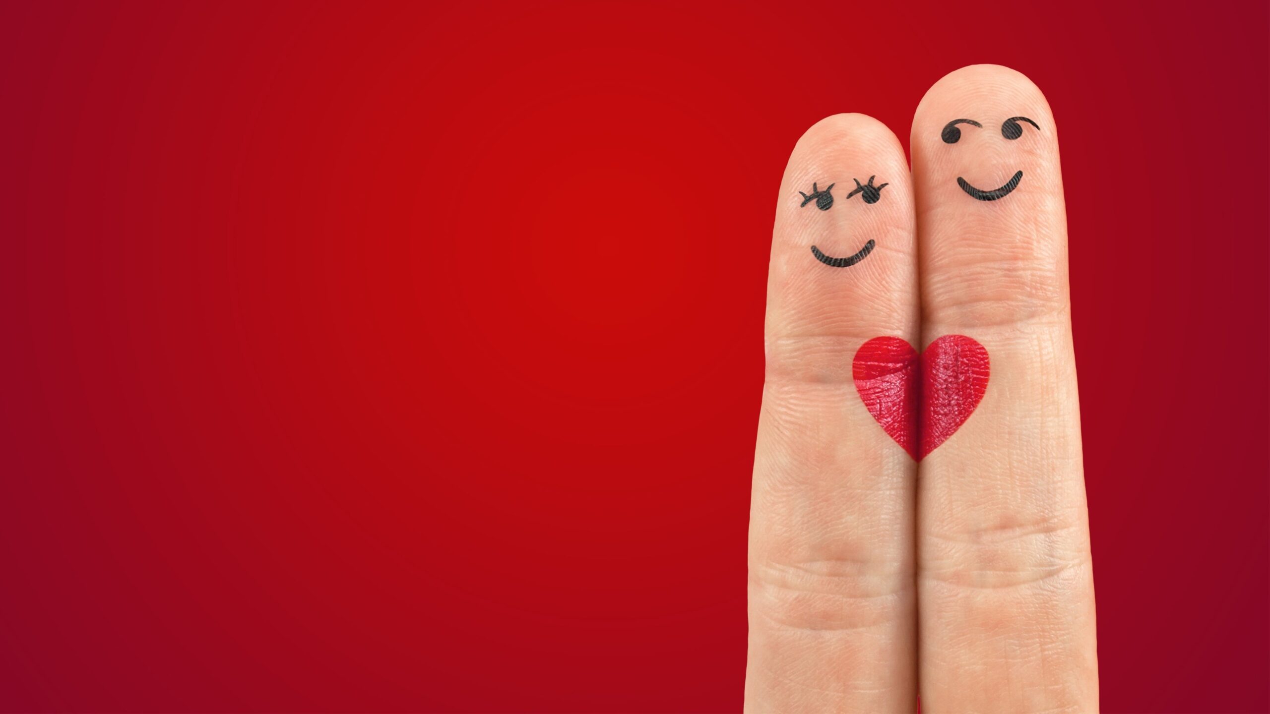 Handoefeningen: op een rode achtergrond twee vingers tegen elkaar, met op de vingertoppen getekende gezichtjes, een man en een vrouw. Onder de tekening een rood hart, verdeeld over de vingers.