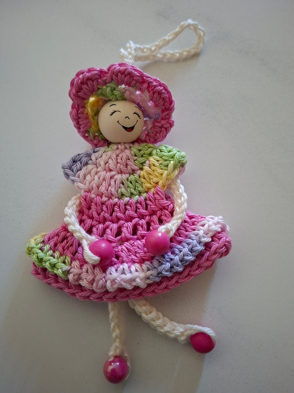 De Overburen, poppetje met jurkje in roze-groen-paars