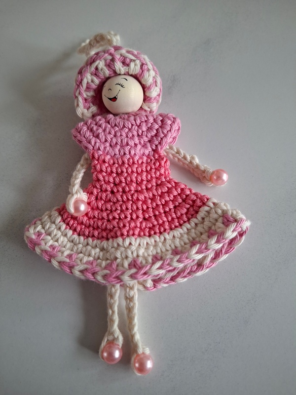 De Overburen, poppetje met jurkje in twee roze tinten en wit en sierrand