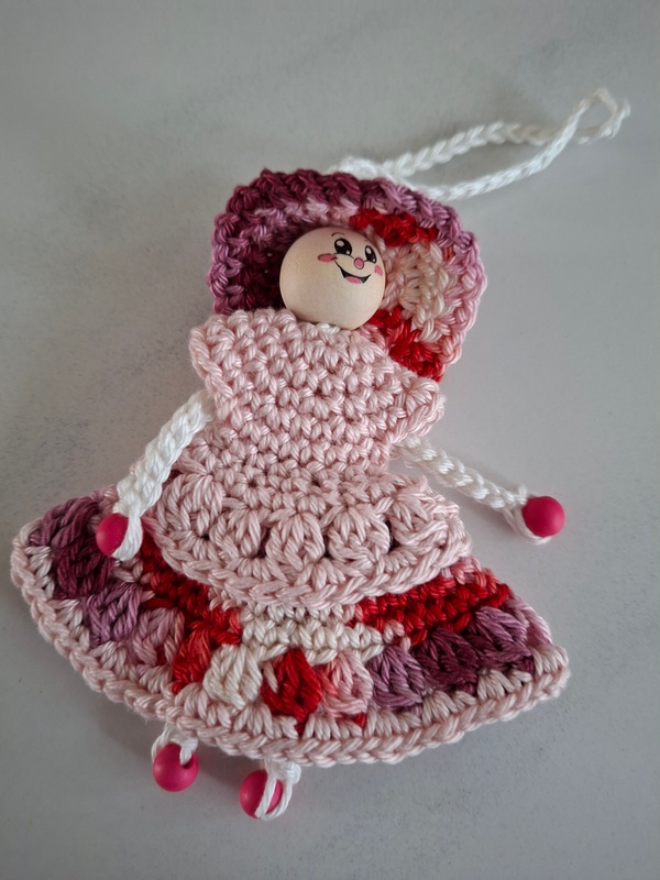 De Overburen, poppetje met roze, overhangende blouse en rok in roze-paarse tinten