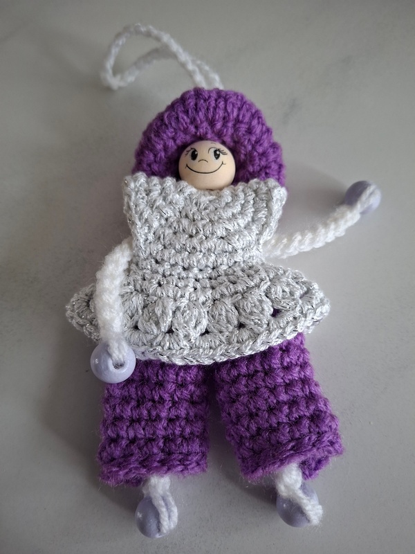 De Overburen, poppetje met witte, lange blouse op paarse broek